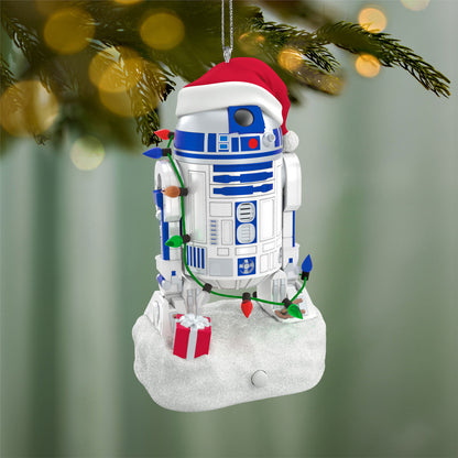 Star Wars™ Decked-Out Droid Musical — 2026 Hallmark Keepsake Christmas Ornament hanging on a tree, wearing a Santa hat and decorative lights.