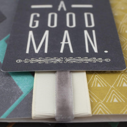 Hallmark birthday greeting card to son (Good Man, Great Son) featuring a dark cover with an embossed message and ribbon bookmark detail.