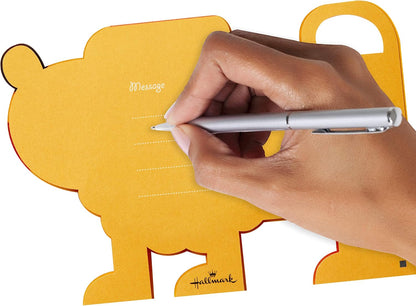 Hallmark Pop Up Birthday Card (3D Honeycomb Lion) with a hand writing a personalized message on the flat yellow card.