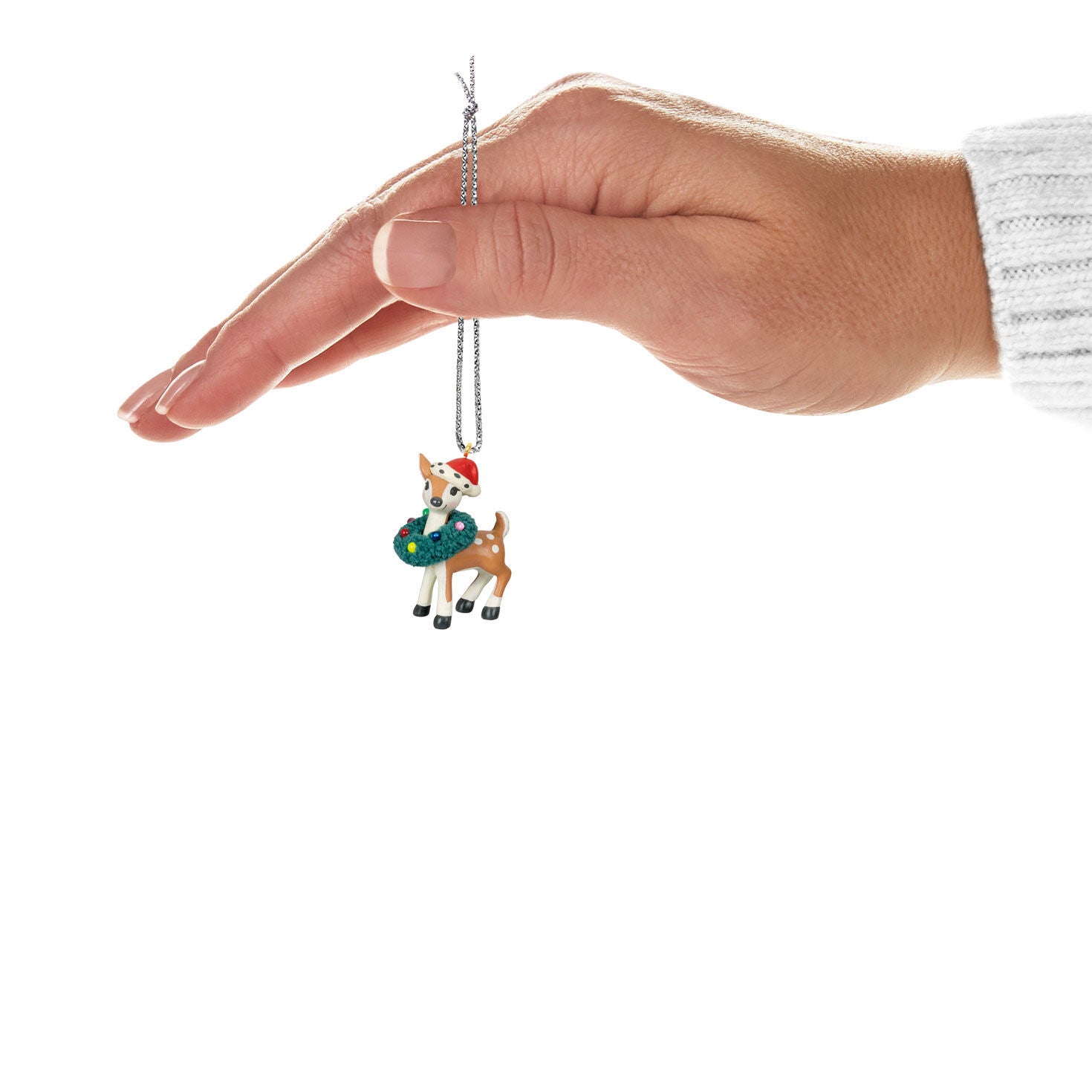 Retro Reindeer (Miniature) — Hallmark Keepsake Christmas Ornament held by hand, featuring red Santa hat and green wreath detail.