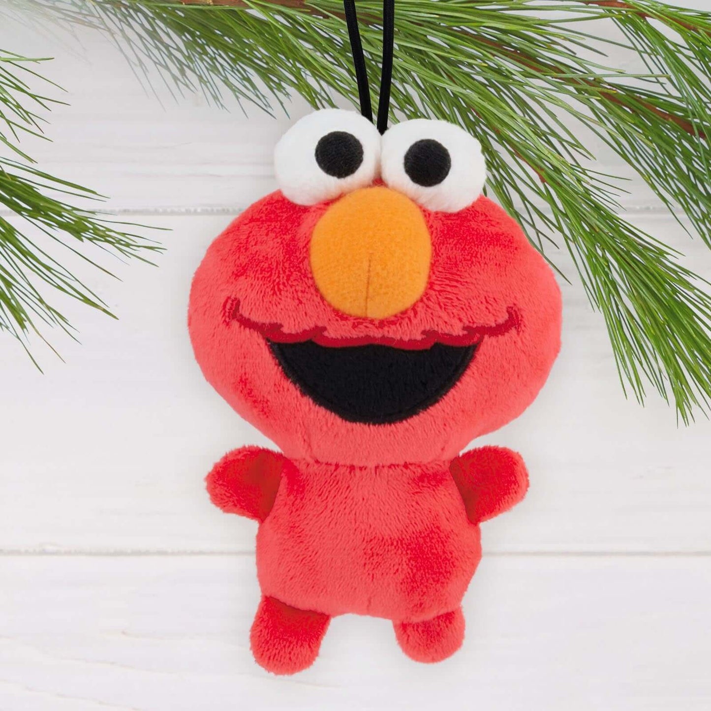 Sesame Street Elmo, Fabric - Hallmark Christmas Ornament in red plush with smiling face, hanging among pine branches.