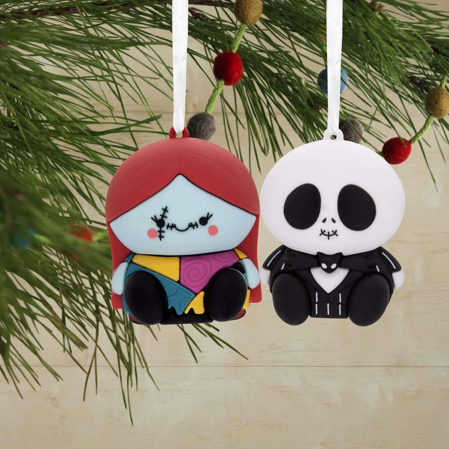 Better Together Disney Tim Burton's The Nightmare Before Christmas Jack and Sally Magnetic, Set of 2 hanging ornaments featuring soft designs on a festive pine background.