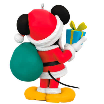 Disney All About Mickey! Santa Mickey — Hallmark Keepsake Christmas Ornament in Santa suit holding a gift and bag at an angled view.