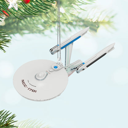 Star Trek™: The Motion Picture U.S.S. Enterprise NCC-1701 Refit (Miniature) — Hallmark Keepsake Christmas Ornament hanging from a tree branch with a blurred festive background.