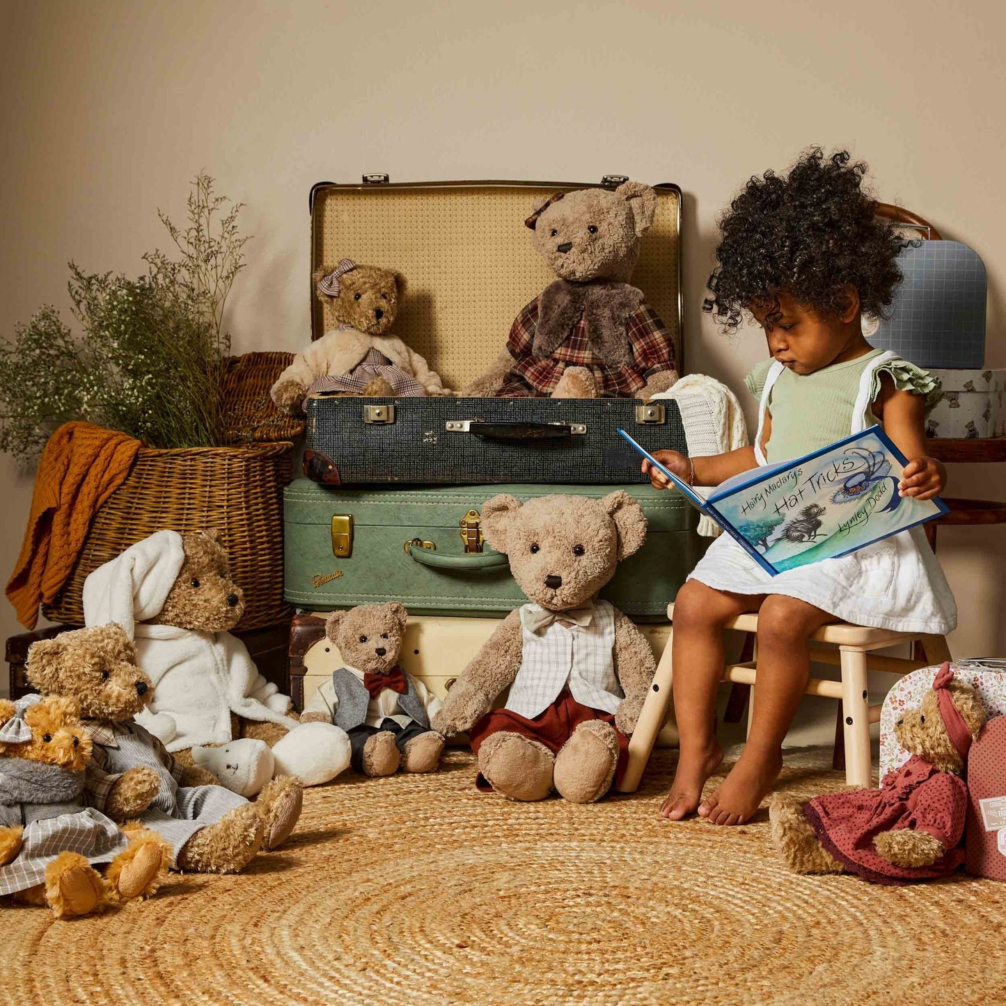 Wilbur the Notting Hill Bear sitting among various teddy bears with a child reading a book in a cosy setting.