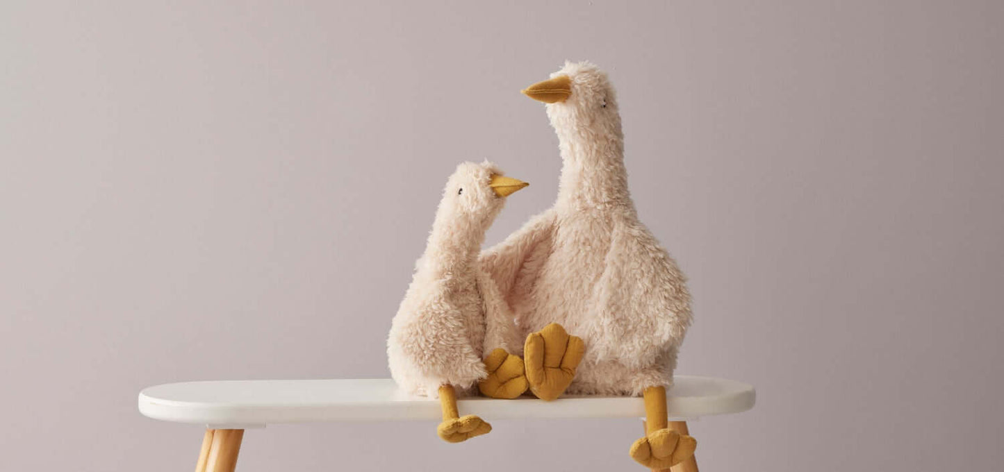 Wiggles the Duck plush toy set in cream, featuring a large duck and a smaller duck, displayed on a white table against a muted background.