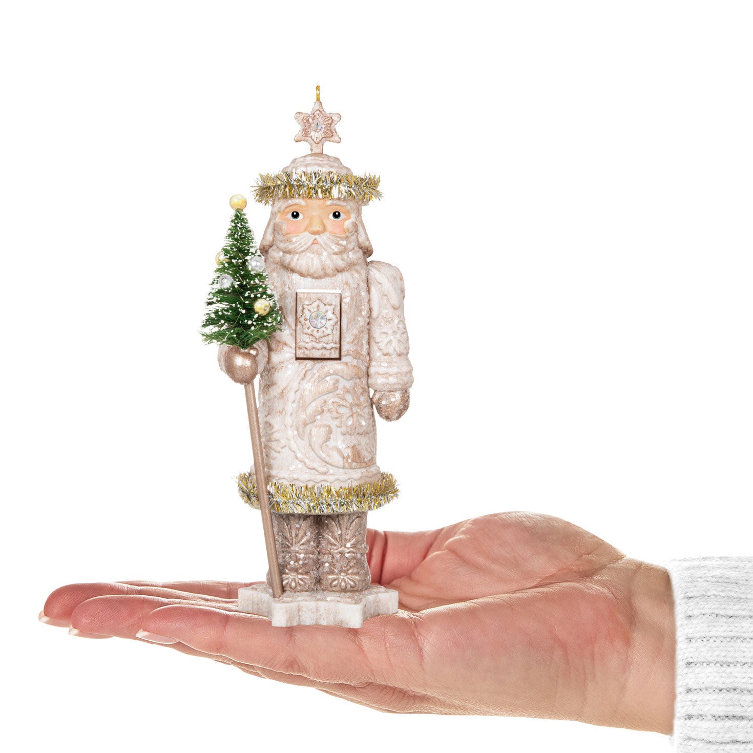 Noble Nutcrackers Earl of Snowfall — Hallmark Keepsake Christmas Ornament in hand, winter white design, with a green tree and star topper.