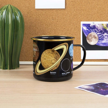 Gift Republic - Astronomia Enamel Mug featuring planetary designs, displayed on a desk with a cactus plant and educational images.