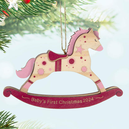 Baby girl's first Christmas rocking horse wood — Hallmark Keepsake Christmas ornament with pink and gold accents, close up view.