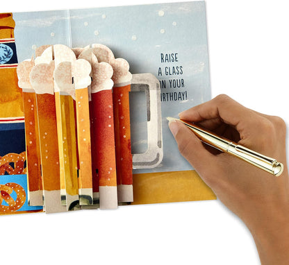Hallmark Paper Wonder Displayable Pop Up Birthday Card (Beer) featuring a 3D pop-up of frothy mugs and a handwritten message.