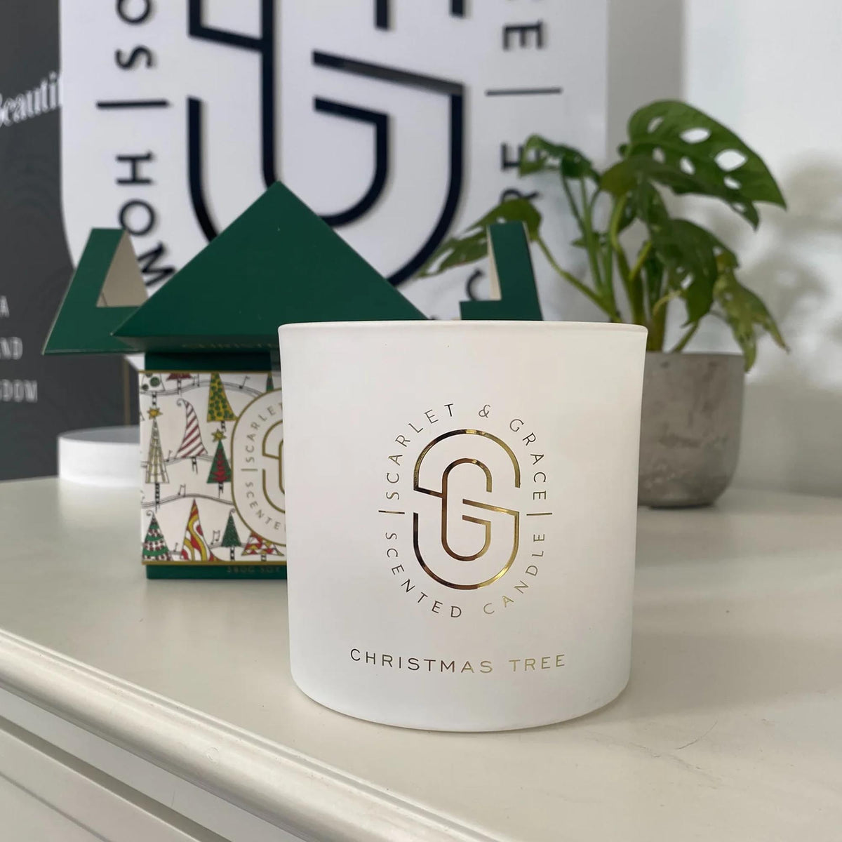 Christmas Tree Candle - Limited Edition (380g) in frosted glass jar with golden branding and festive packaging in background.