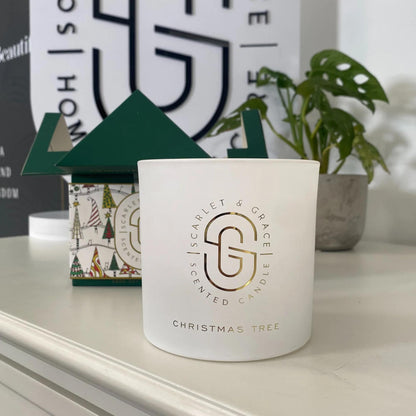 Christmas Tree Candle - Limited Edition (380g) in frosted glass jar with golden branding and festive packaging in background.
