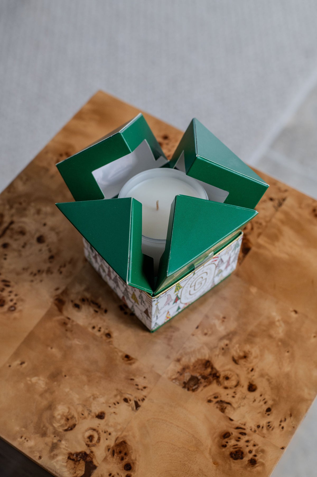 Christmas Tree Candle - Limited Edition (380g) in a festive green box, top view, placed on a wooden table.