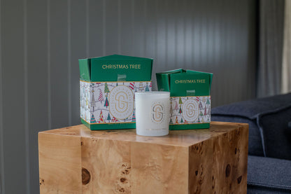 Christmas Tree Candle - Limited Edition (380g) in gift packaging on wooden table, featuring festive design and seasonal colours.