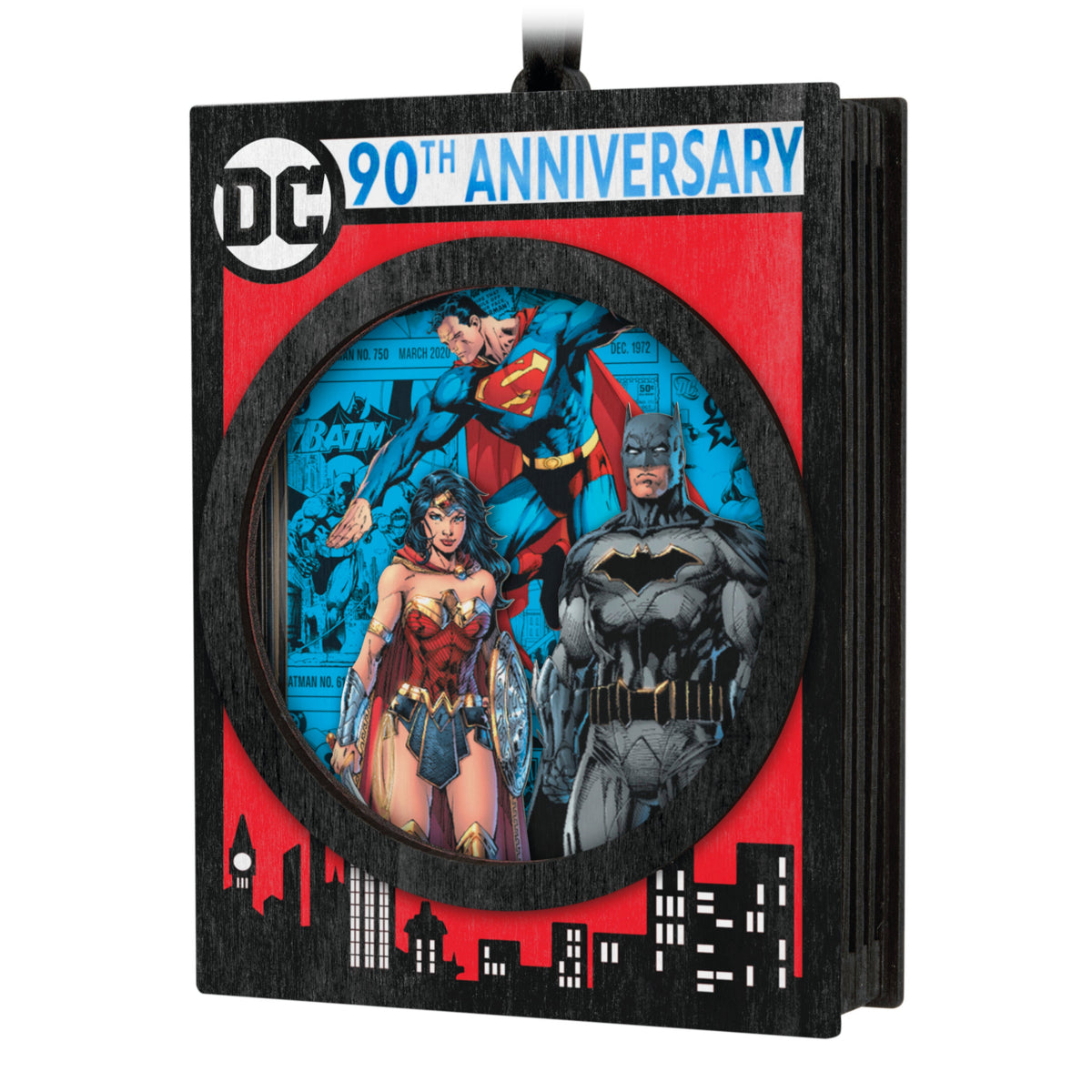 DC™ Comics 90th Anniversary — 2025 Hallmark Keepsake Christmas Ornament featuring laser-cut wood frame with Superman, Batman, and Wonder Woman papercraft design, angled view.