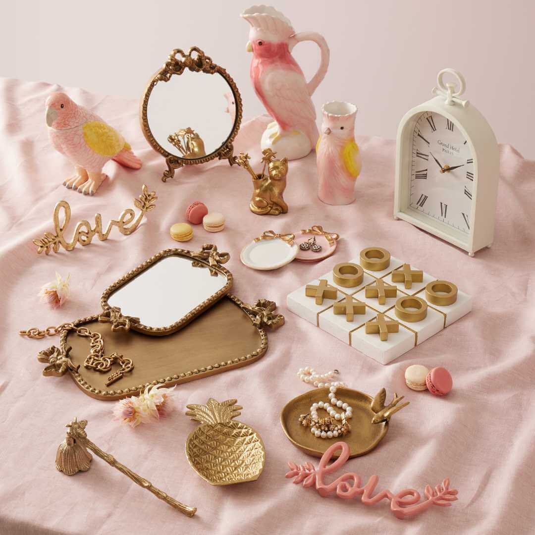 Bridie Vase - Pink displayed with decorative items like a mirror, clock and playful sculptures on a soft pink background.
