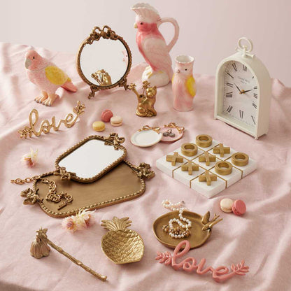 Bridie Vase - Pink displayed with decorative items like a mirror, clock and playful sculptures on a soft pink background.