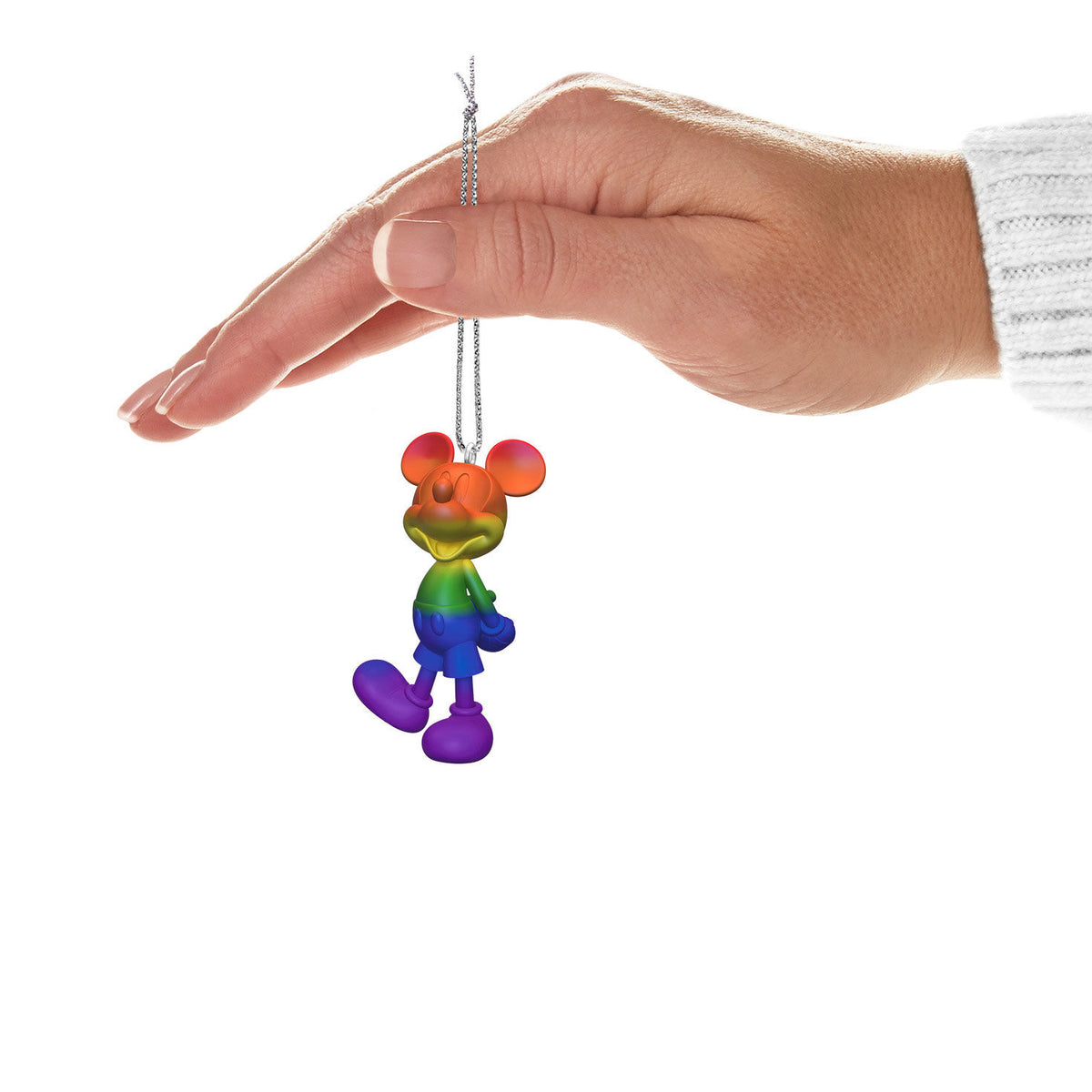 Disney Mickey Mouse, Rainbow Mickey — Hallmark Keepsake Christmas Ornament hanging from a hand, showcasing vibrant rainbow colours and detailed design.