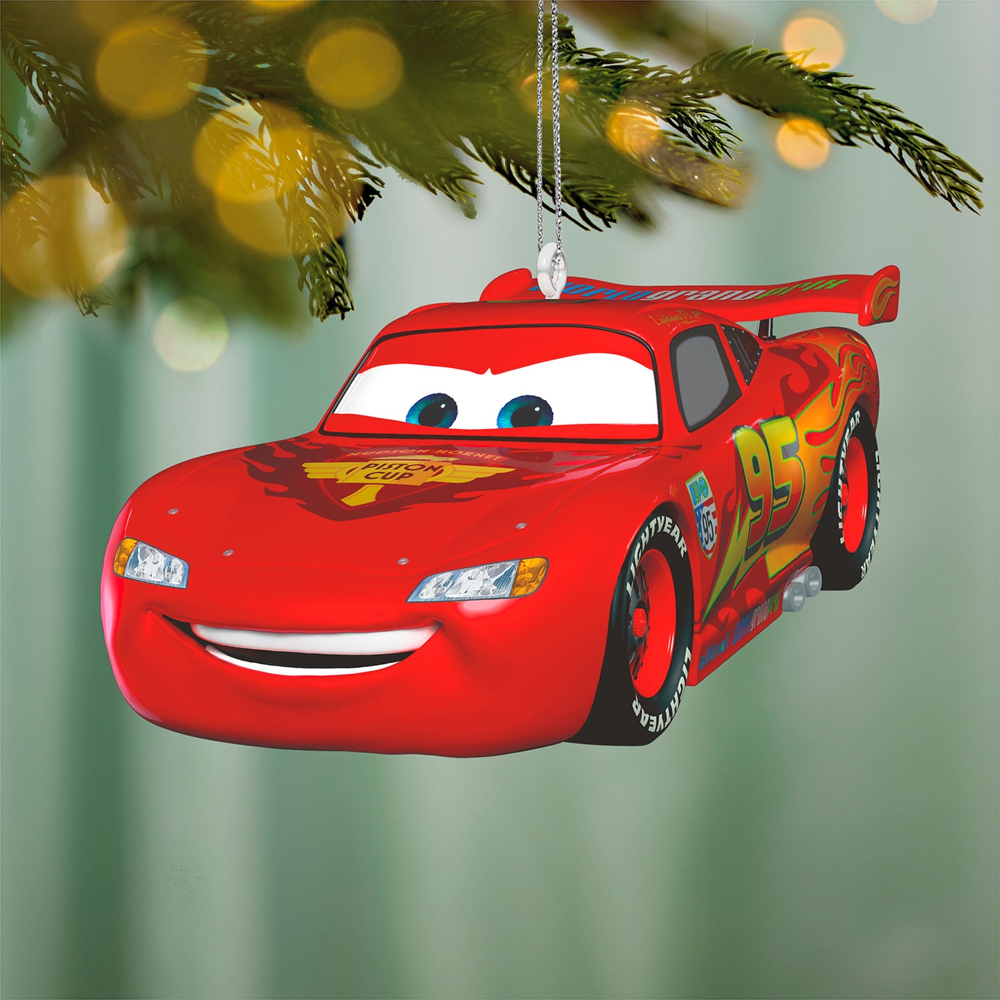 Disney/Pixar Cars 2 15th Anniversary Lightning McQueen, metal ornament with vibrant red colour and smiling face, hanging on a tree.