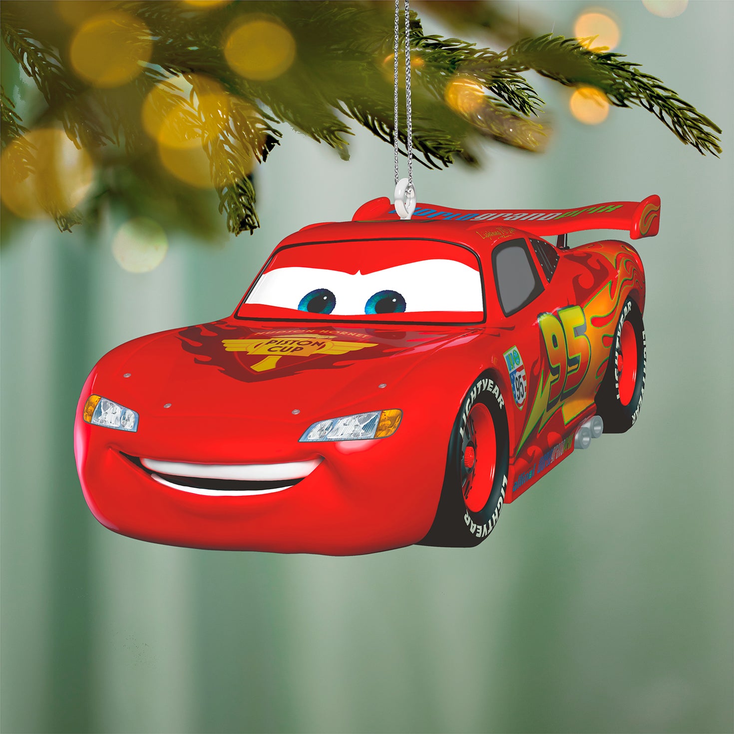 Disney/Pixar Cars 2 15th Anniversary Lightning McQueen, metal ornament with vibrant red colour and smiling face, hanging on a tree.