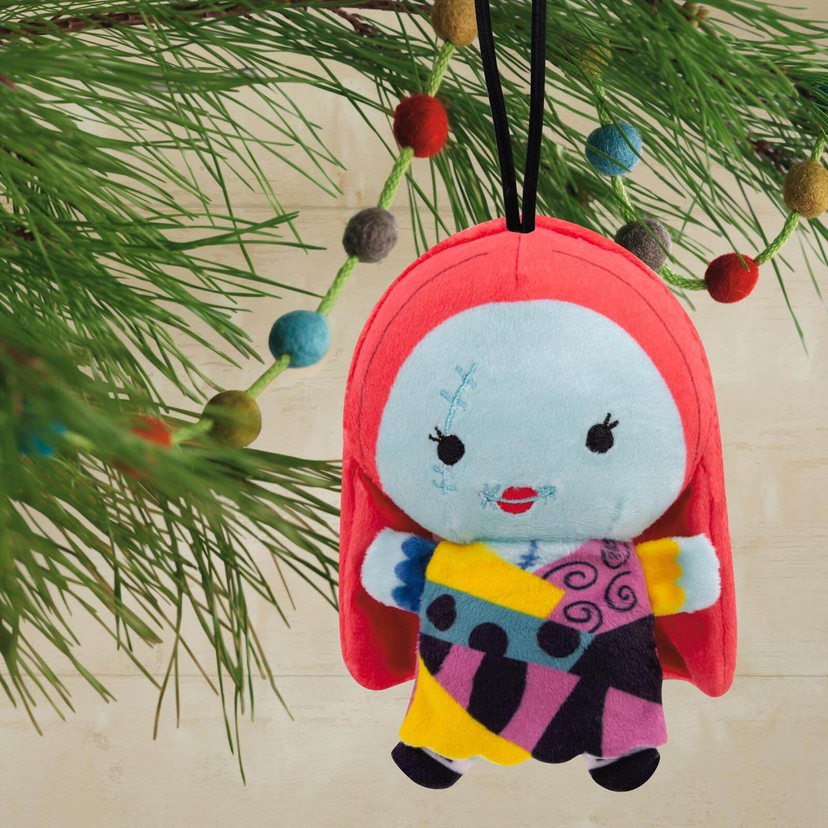 Disney Tim Burton's The Nightmare Before Christmas Sally, plush fabric Christmas ornament with bright colours and whimsical design, hanging on a tree.