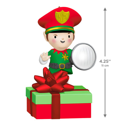 Elf Security Peekbuster With Motion-Activated Sound and Light — 2026 Hallmark Keepsake Christmas Ornament on a gift box, featuring a smiling elf in a red cap holding a flashlight.