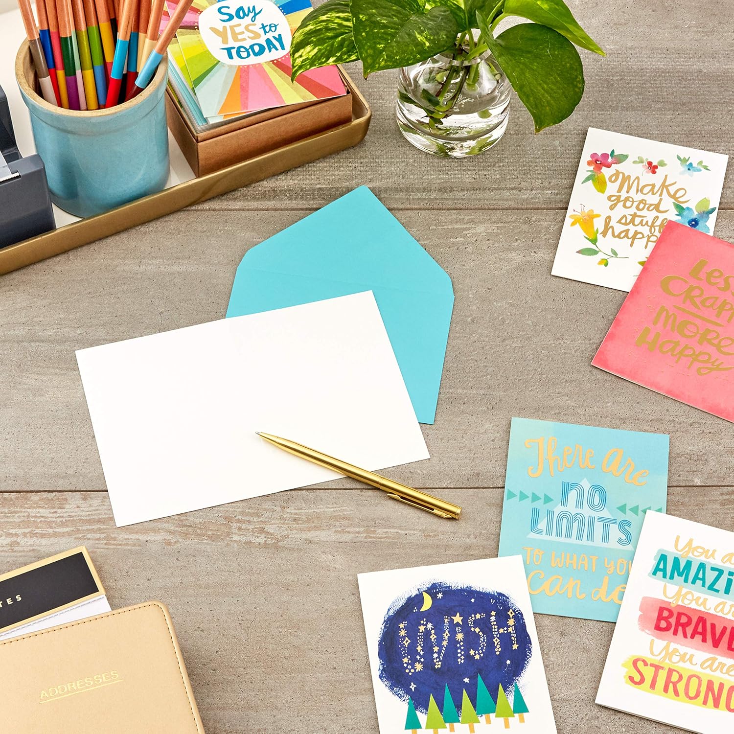 Hallmark Thinking of You, Encouragement, Get Well, Sympathy Cards Assortment (24 Assorted Cards and Envelopes) displayed with an envelope, pen, and bright stationery on a wooden table.