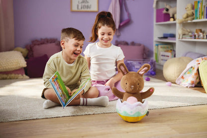Excited for Eggs Bunny Plush With Sound and Motion in playtime scene, featuring children enjoying a colourful plush bunny toy.