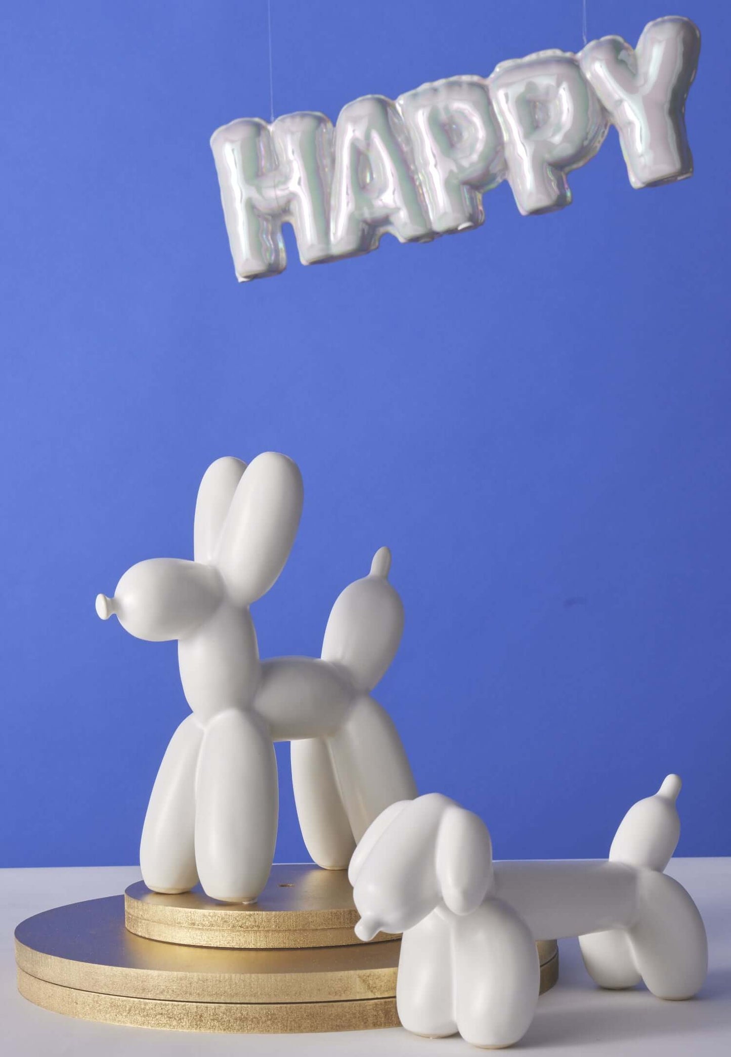 Happy Balloon Sculpture 34x5x11cm featuring white balloon dog figurines with a shiny HAPPY sign above on a blue background.
