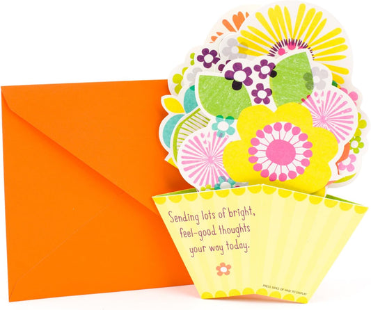 Hallmark Get Well Greeting Card (Pop-Up Flowers) with vibrant floral design, bright yellow pot, and orange envelope in flat lay view.