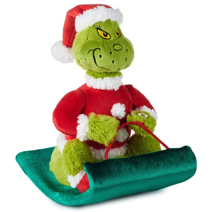 Dr. Seuss's How the Grinch Stole Christmas!™ Grinch on sled musical plush with motion dressed in Santa suit on a green sled.