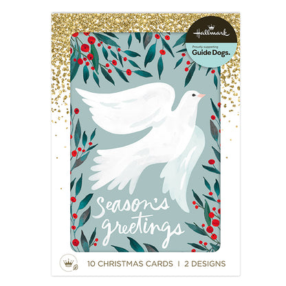 Hallmark Christmas Guide Dogs card set featuring a white dove illustration surrounded by red berries and green leaves on a muted blue-gray background, with gold glitter accents and a white border. Text at the bottom reads '10 Christmas Cards | 2 Designs'.