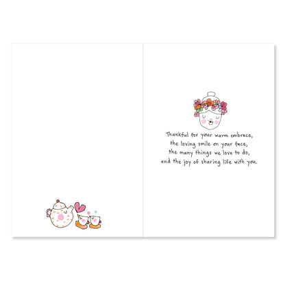 Card with cartoon teapot and cups on one side and floral design and text on the other, on a white background.