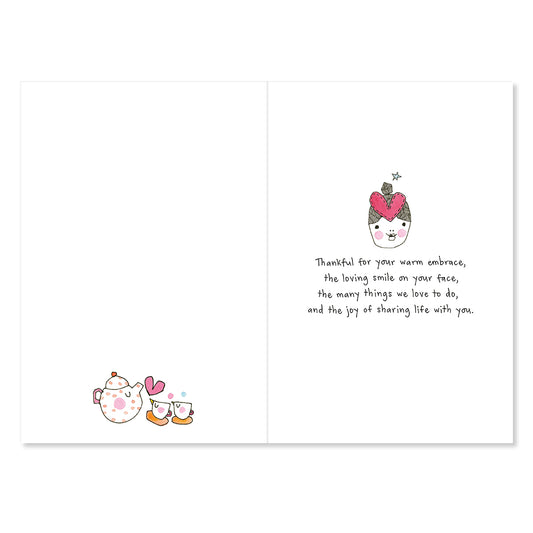 Greeting card with illustrations of a teacup and hearts, and text on a white background