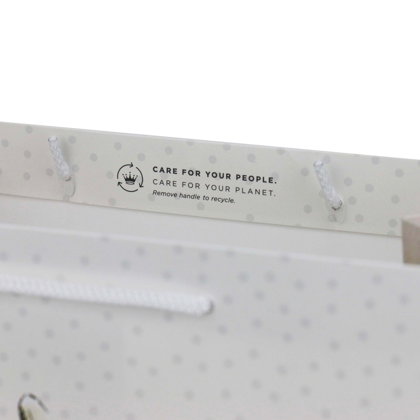 Hallmark Peter Rabbit™ large gift bag handles with recycling message and white cord detailing, top angle view.