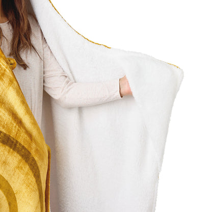 Harry Potter™ Golden Snitch™ Hooded Blanket in soft fleece, showing the white interior lining and golden exterior, model holding blanket.