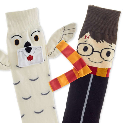 Harry Potter™ and Hedwig™ novelty crew socks featuring Hedwig with wings and Harry with glasses in a flat lay arrangement.