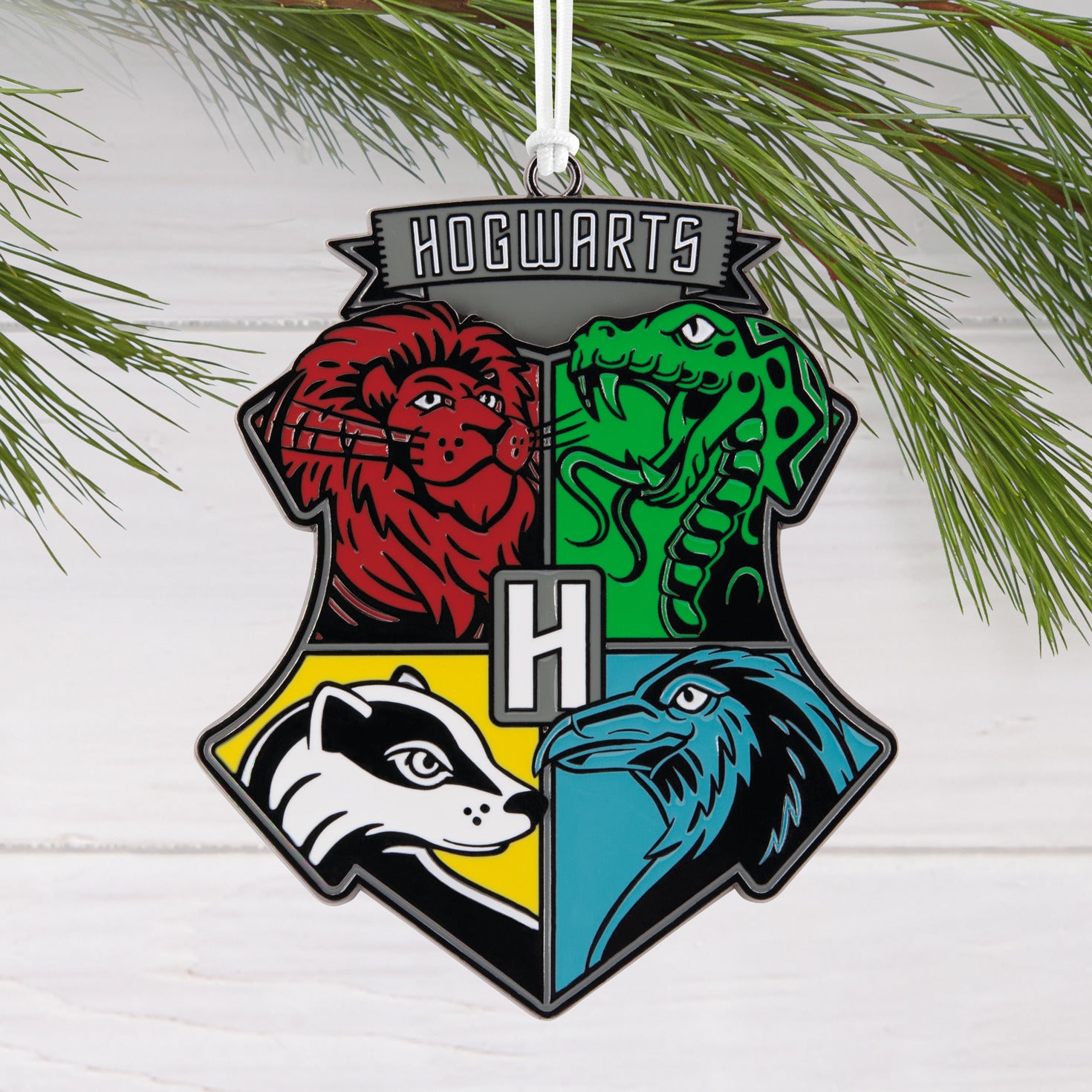 Harry Potter™ Hogwarts™ Crest Moving Metal Hallmark Ornament featuring all four house symbols with colourful design and metal finish.