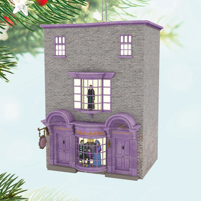 Harry Potter™ Madam Malkin's Robes for All Occasions™ — Hallmark Keepsake Christmas Ornament, detailed purple building with windows, festive background.