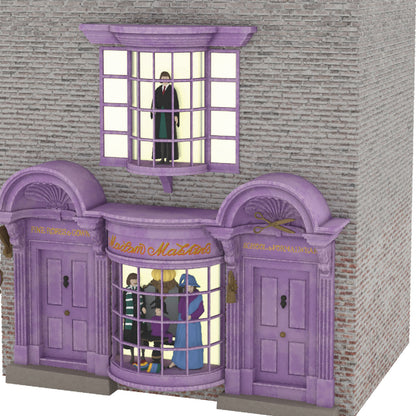 Harry Potter™ Madam Malkin's Robes for All Occasions™ — Hallmark Keepsake Christmas Ornament showcasing a detailed shop front with purple entrance and figures inside.