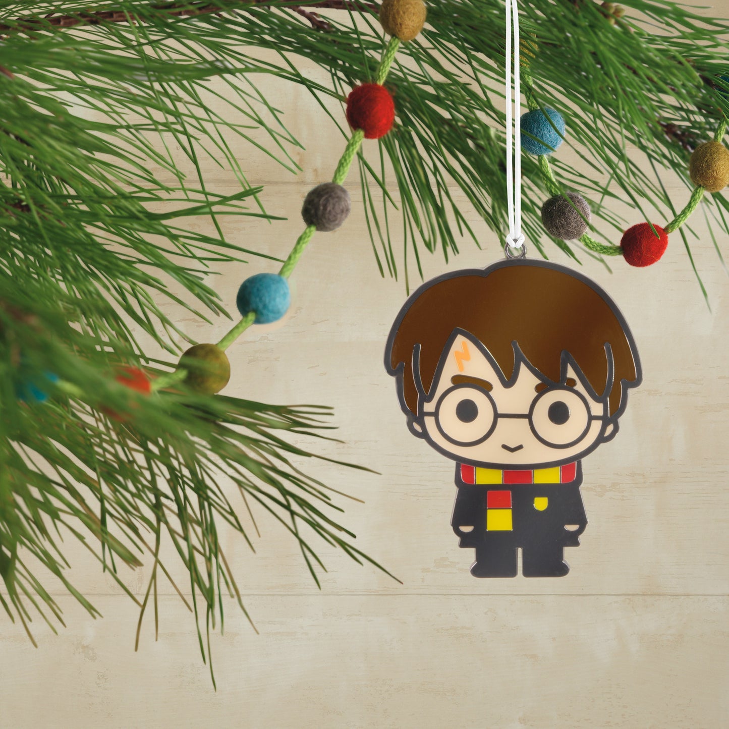 Harry Potter™ Moving Metal Hallmark Ornament, colourful character design, hanging on a pine tree branch with festive decorations.