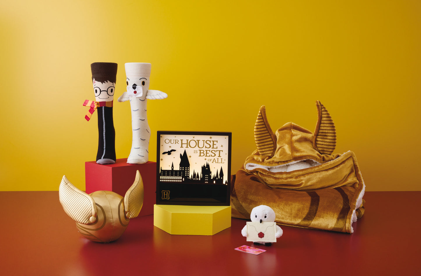 Harry Potter™ and Hedwig™ Novelty Crew Socks displayed with other themed merch including a Quidditch set and Hogwarts decor.