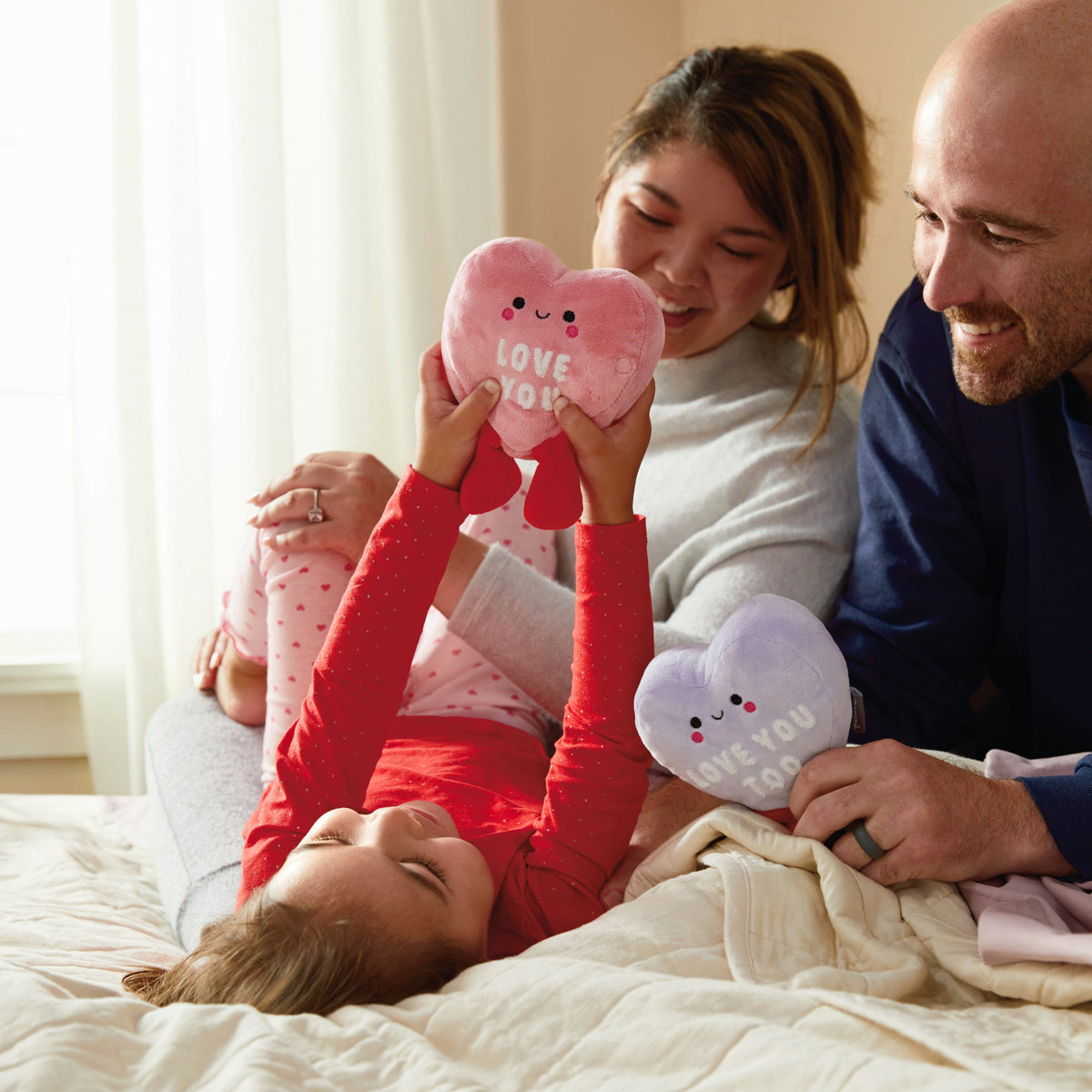 Love Hearts, Magnetic Plush - Better Together in a family scene with a child and parents enjoying the soft plush pillows.