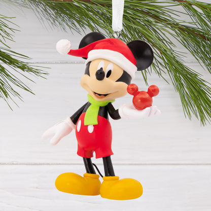 Hallmark Christmas Ornament - Disney Mickey Mouse Holding Ornament, colourful figurine, wearing a Santa hat, shown hanging on a pine branch.