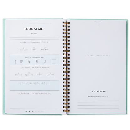 My First Year Baby Book - Blue open page layout with journal prompts and writing spaces for baby milestones and memories.