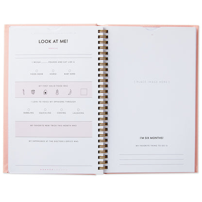 My First Year Baby Book - Pink interior pages featuring prompts for baby's milestones and memories, displayed with a spiral binding.