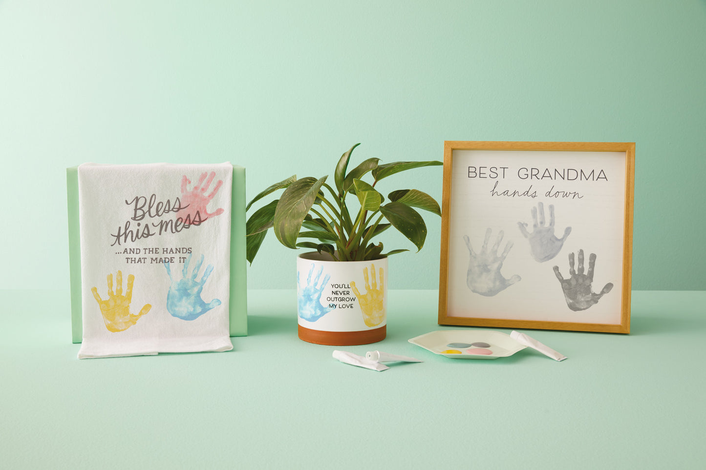 Never Outgrow My Love Planter Handprint Kit displayed with handprint art and message decor, featuring a ceramic planter and painted handprints.