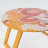 Abstract foldable picnic table featuring a vibrant pink and yellow design, close-up view of tabletop detailing.