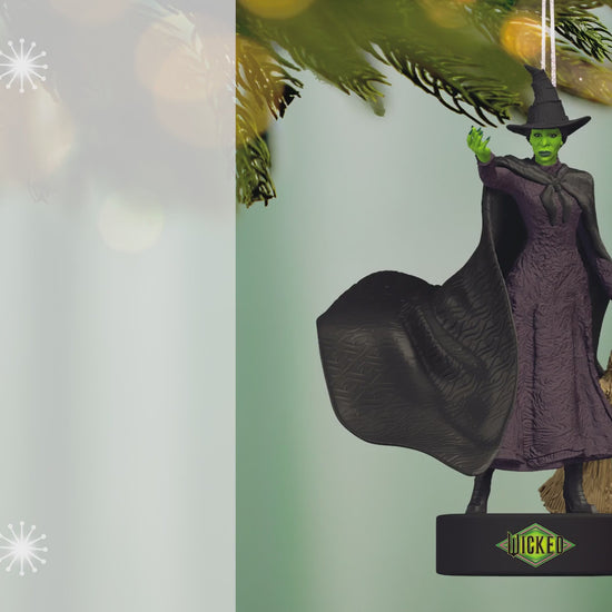 Wicked Defying Gravity With Sound — 2026 Hallmark Keepsake Christmas Ornament featuring the Wicked Witch of Oz in black dress and hat, hanging from a tree.
