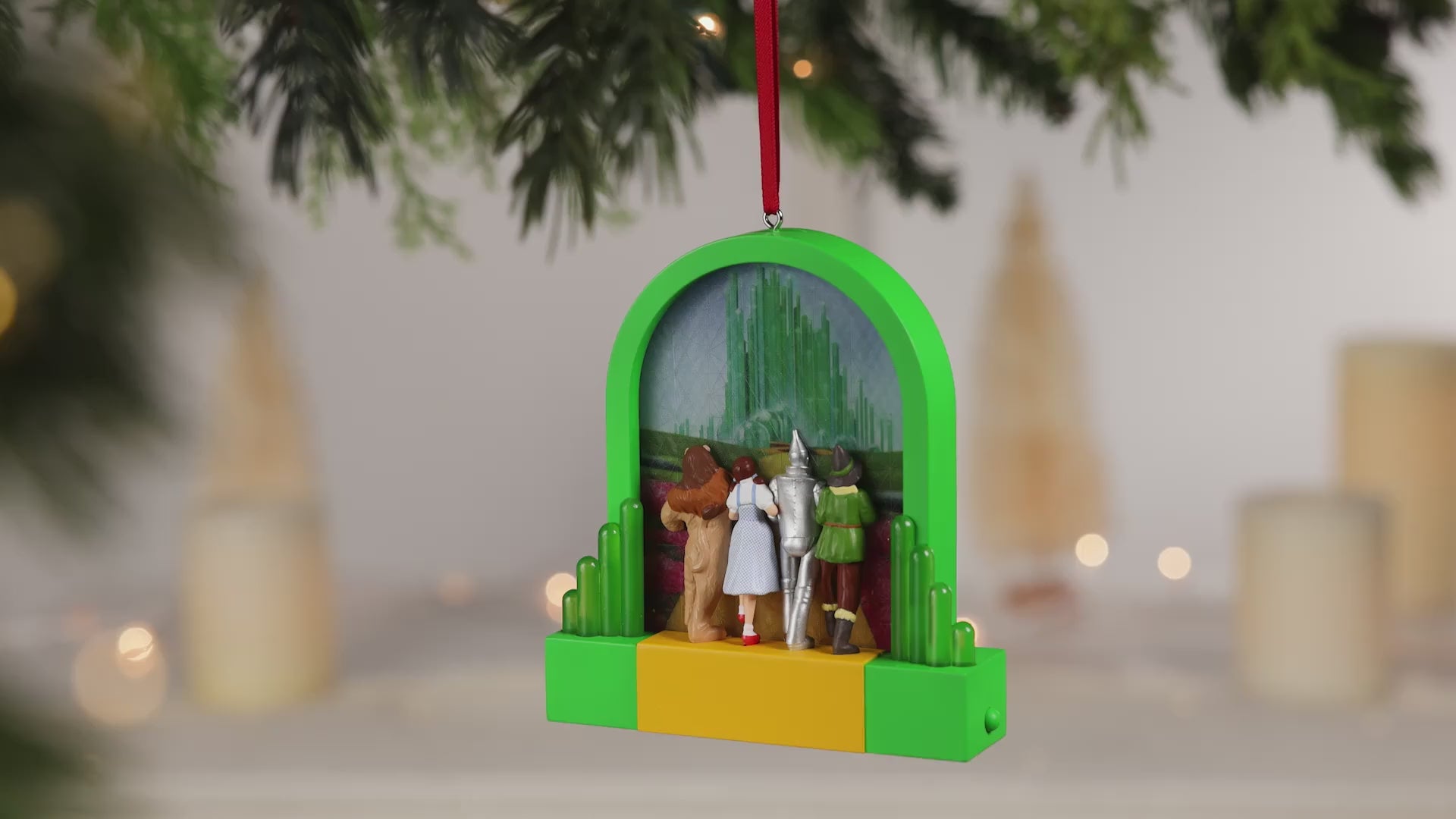 The Wizard of Oz™ Journey to the Land of Oz With Light — 2026 Hallmark Keepsake Christmas Ornament hanging among decorations, vibrant green details.